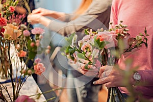 Workshop florist, making bouquets and flower arrangements. Woman collecting a bouquet of roses. Soft focus