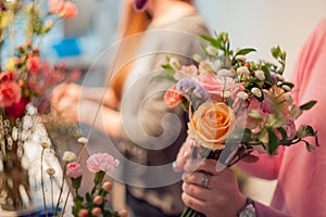 Workshop florist, making bouquets and flower arrangements. Woman collecting a bouquet of roses. Soft focus