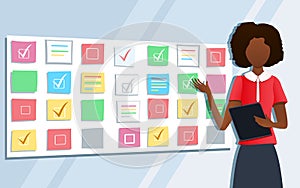 Workshop training. Business consultant pointing at scrum task board plan. Professional female coach standing at whiteboard