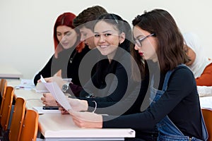 Workshop at university. View of students sitting and listening in lecture hall doing practical works