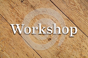 `Workshop` white text on a wooden background.