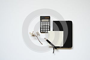 Workspace. black notebook, memopad, calculator, pencil on white desk background. flat lay, top view