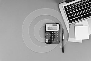 Workspace with calculator, black pen, laptop on black and White background concept