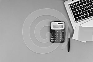 Workspace with calculator, black pen, laptop on black and White background concept