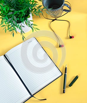 Workspace - creative flat photo of the desktop. Top view office desk with laptop, notebook and datebook against yellow background