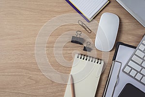 Workspace with diary or notebook and clipboard, laptop, mouse computer, keyboard, smart phone, pencil, pen on wooden background