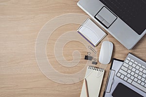 Workspace with diary or notebook and clipboard, laptop, mouse computer, keyboard, smart phone, pencil, pen on wooden background