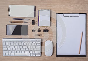 Workspace with diary or notebook and clipboard, mouse computer, keyboard, smart phone, pencil, pen on wooden background