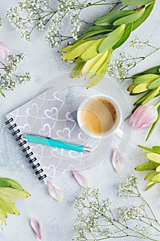 Workspace with diary, notebook, pen, flowers on light blue background