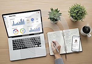 A workspace featuring a laptop displaying analytics graphs, a