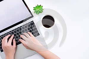 A workspace with a laptop on a simple table and a woman`s hand is working. With a copy area in the business concept