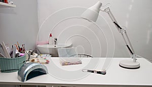 Workspace of a manicurist with tools, pallets, tongs, varnishes