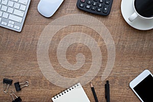 Workspace in office with wood table. Top view from above of keyboard with notebook and coffee. Desk for modern creative work of de