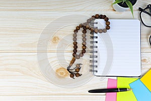 Workspace with Pen, spectacles, decoration flower, rosary and book.Copy Space