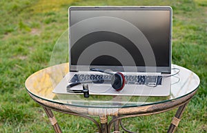 Workstation, work from home, spring in the garden, on a laptop with a helmet