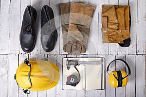 Workwear for a production worker on a white table. Personal protection accessories and measuring tools used at work photo