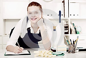 workwoman of office cleaning service wiping dust on sleek table