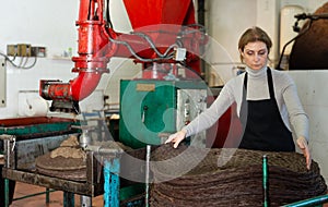 Workwoman stacking fiber mats with olive paste