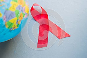 World AIDS day 1 December, close-up of world globe with red ribbon