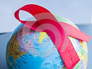 World AIDS day 1 December, close-up of world globe with red ribbon