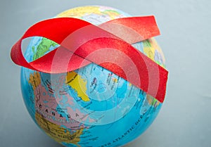 World AIDS day 1 December, close-up of world globe with red ribbon