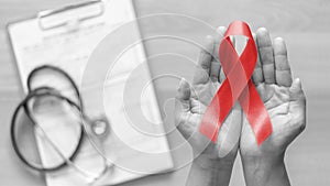 World aids day and national HIV/AIDS and ageing awareness month with red ribbon on woman hand support bow isolated clipping path