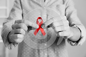 World AIDS disease day. Woman holding red awareness ribbon, closeup