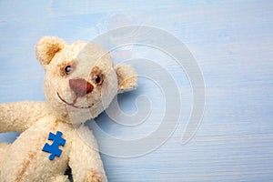 World Autism Awareness day, concept with teddy bear holding puzzle or jigsaw element