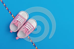 World Autism Awareness day, mental health care concept with pink baby shoes and ribbon puzzle pattern. On blue background