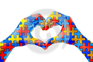 World Autism Awareness day, mental health care concept with puzzle jigsaw pattern on heart shape hands.