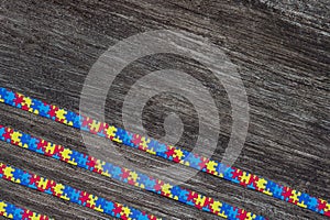 World Autism awareness day with Puzzle ribbon on wooden background