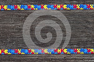 World Autism awareness day with Puzzle ribbon on wooden background