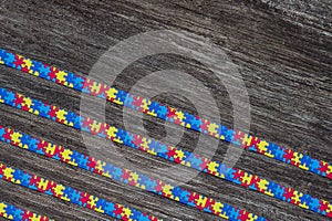 World Autism awareness day with Puzzle ribbon on wooden background