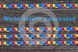 World Autism awareness day with Puzzle ribbon on wooden background