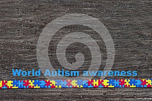 World Autism awareness day with Puzzle ribbon on wooden background