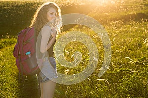 A world without borders. Stunning journey of girl in the mountains. Young traveller enjoying a looking at sunset, active