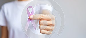 World cancer day February 4. Woman hand holding Lavender purple ribbon for supporting people living and illness. Healthcare and