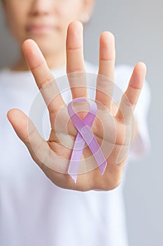 World cancer day February 4. Woman hand holding Lavender purple ribbon for supporting people living and illness. Healthcare and