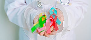 World cancer day, February 4. Doctor hold colorful ribbons, blue, yellow, red, green, white, pink and grey for supporting people