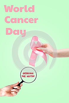 World cancer day. Females hand with a pink ribbon and a magnifying glass on a light green background. Vertical orientation. Copy