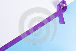 World cancer day  purple ribbon on with and blue background with copy space for text. Healthcare and medical concept