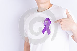 World cancer day  purple ribbon on chest isolated grey background. Healthcare and medical concept