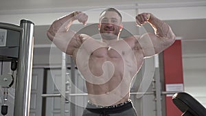 The world champion of bodybuilding posing in the gym. Slowly