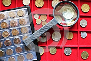 Numismatic, world coins collection on a red tray. photo