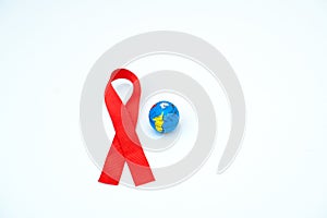 World day of fight against AIDS. The symbols are a red ribbon and an imitation globe on a white background. This day is