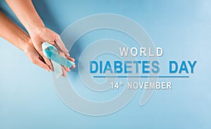 World diabetes day awareness concept. Hand holding blue ribbon, symbolic bow color raising awareness in diabetes day on pastel