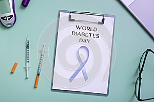 World Diabetes Day text with blue ribbon and glucometer, medical supplies on color background top view