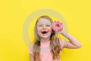 World Donut Day or No diet day. A little girl holding donuts and smiling, holding on a yellow background. The concept. kids and