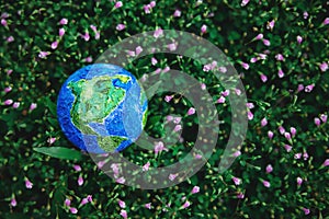 World Earth Day Concept. Green Energy, ESG, Renewable and Sustainable Resources. Environmental Care. Globe Lay on Green Grass.