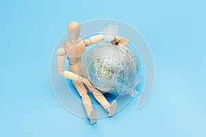 .World Environment Day concept. Symbol wooden man and planet earth globe. The consequence of environmental pollution will be the